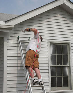 Professional painter from Hershey Handyman doing exterior paint job in Hershey, PA